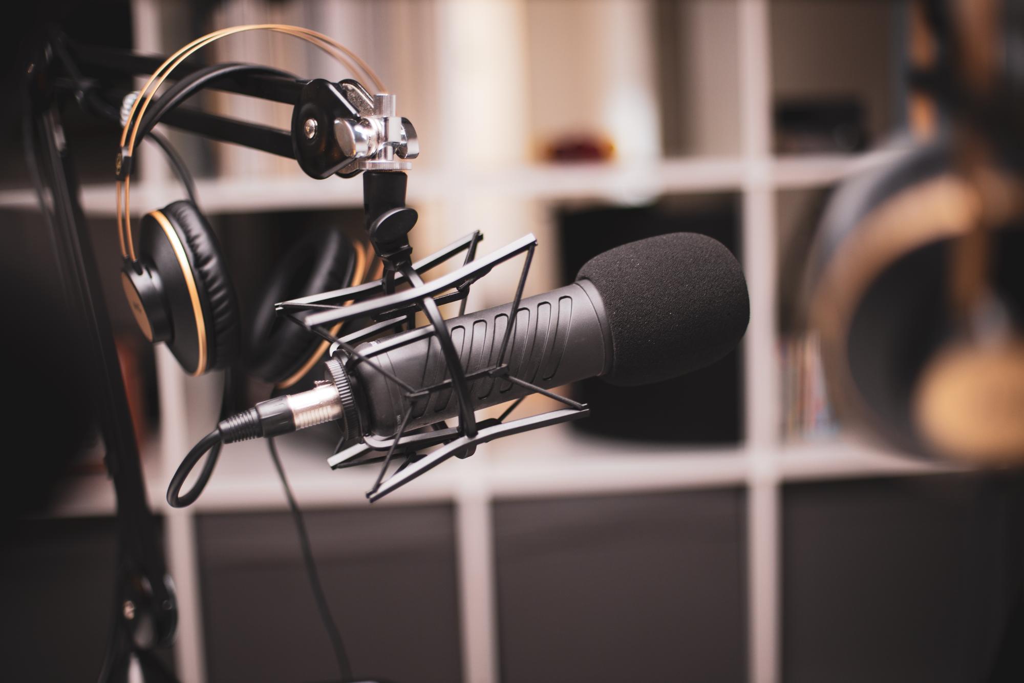 Side on a shot of a podcasting set-up with headphones and a professional microphone by Jonathan Farber